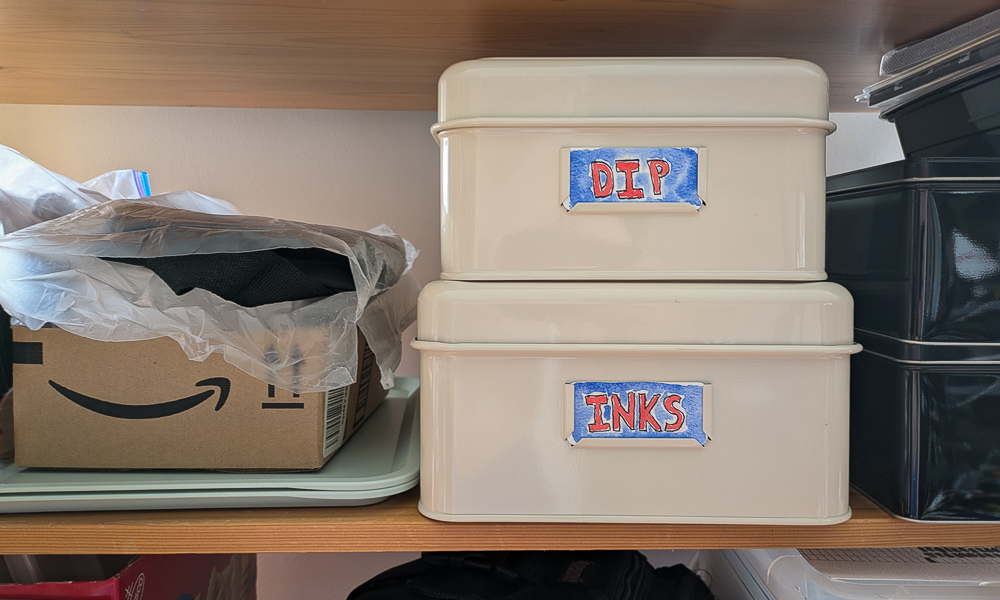 Two metal storage bins with painted labels of "Inks" and "Dip"